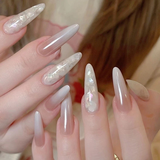 Long oval nude pink press-on nails with pearly shell accent designs