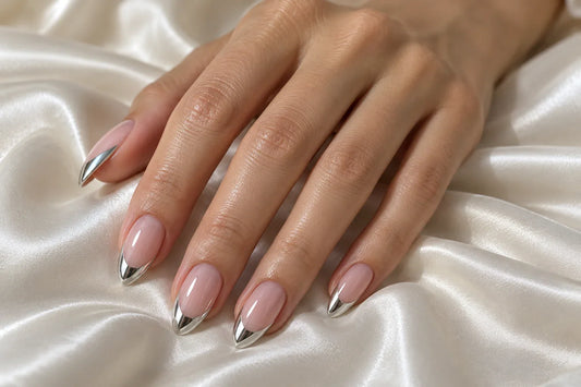 Almond nails with sheer pink bases and reflective silver French tips.