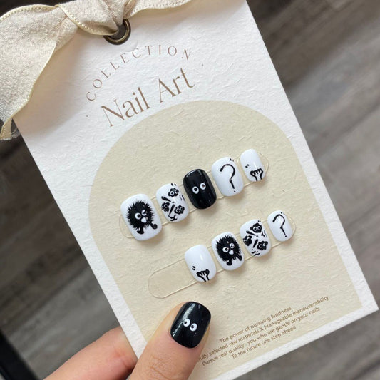 Press-on nails inspired by Ghibli's Soot Sprites (Susuwatari), featuring a playful design with black and grey motifs on a clear background to mimic the whimsical creatures.