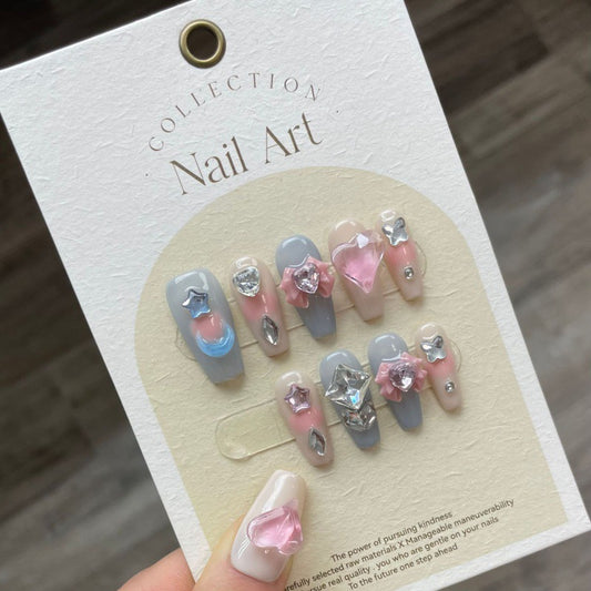 Set of press-on nails titled 'Love is Blue' featuring shades of azure, cobalt, and sky blue with heart-shaped accents, perfect for stylish nail art lovers.