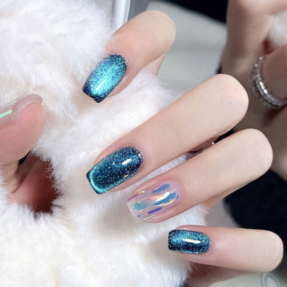 Close-up of nails with a cat eye effect: "Close-up view of fingernails painted with BOMD cat eye gel polish, featuring a mesmerizing magnetic shimmer effect in a deep blue shade."