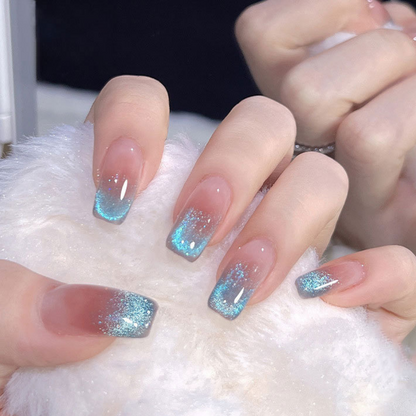 Close-up of nails with a cat eye effect: "Close-up view of fingernails painted with BOMD cat eye gel polish, featuring a mesmerizing magnetic shimmer effect in a light blue shade."