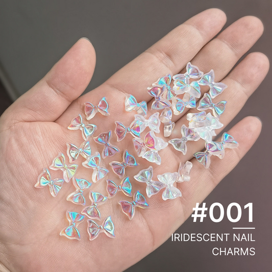 Hand holding a collection of iridescent butterfly nail charms, shimmering in a spectrum of colors, perfect for vibrant nail art enhancements.