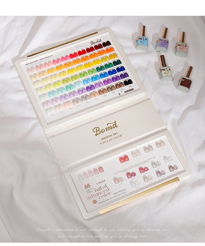 An elegant display of BOMD gel polish colors, featuring a comprehensive color chart with a wide range of vibrant and pastel shades. The open booklet showcases both the 'Magical Gel' and 'Popular Color' collections, with a few bottles of gel polish arranged nearby, emphasizing the diverse and sophisticated options available for nail enthusiasts.