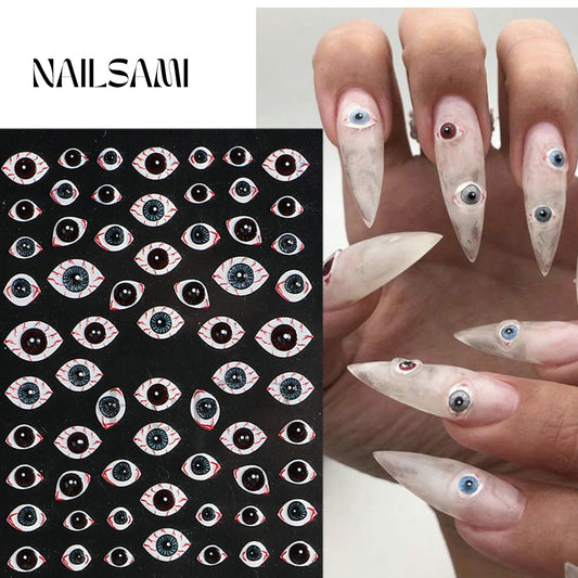 "Eye Spy - Creepy Eyes" nail stickers from NAILSAMI feature a variety of realistic eye designs on a black sheet, applied to nails for a startlingly lifelike look.