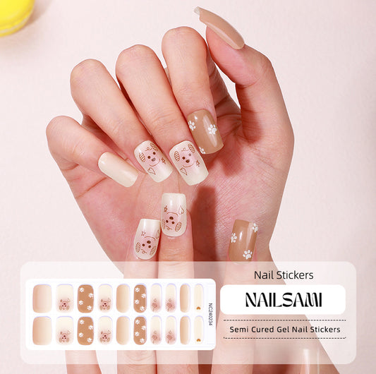 Hand with nails featuring glittery gold accents with delicate patterns, with a NAILSAMI gel nail sticker sheet displayed below showcasing the same gold design.