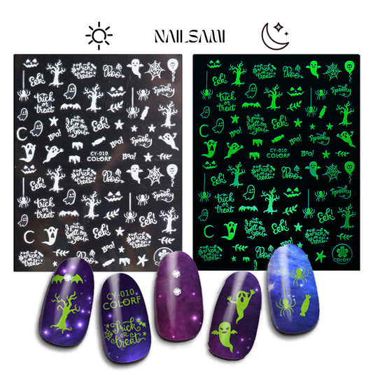 A display of NAILSAMI's "Graveyard Whispers" glow-in-the-dark nail stickers, with designs like ghosts and bats visible in daylight and glowing green in the dark, shown on a black background.