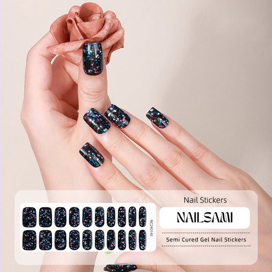 Hand with nails in a deep navy with starry accents gel nail sticker design, with a NAILSAMI gel nail sticker sheet displayed below showcasing the same cosmic design.