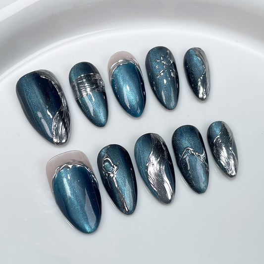 Cute metallic blue Halloween nails with silver accents, perfect for short nail designs