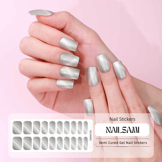 Hand with nails in a metallic silver gel nail sticker design, with a NAILSAMI gel nail sticker sheet displayed below featuring the same silver design.