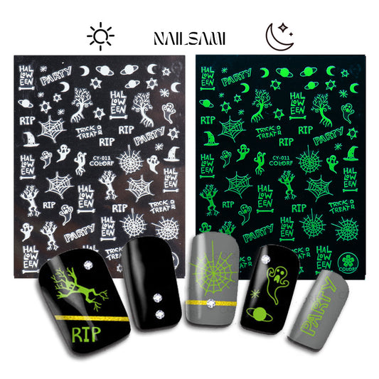 Spooky Shadows - Tombstones & Trees" nail stickers from NAILSAMI show tombstones and tree designs on a grey and black sheet, glowing green in the dark.