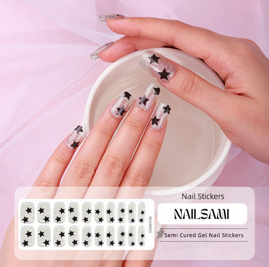 Hand with nails showcasing a black and white star pattern gel nail sticker design, with a NAILSAMI gel nail sticker sheet displayed below featuring the same star design.