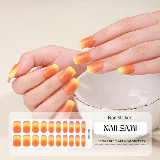 Hand with nails adorned in a warm orange gradient gel nail sticker design, with a NAILSAMI gel nail sticker sheet displayed below featuring the same orange design.