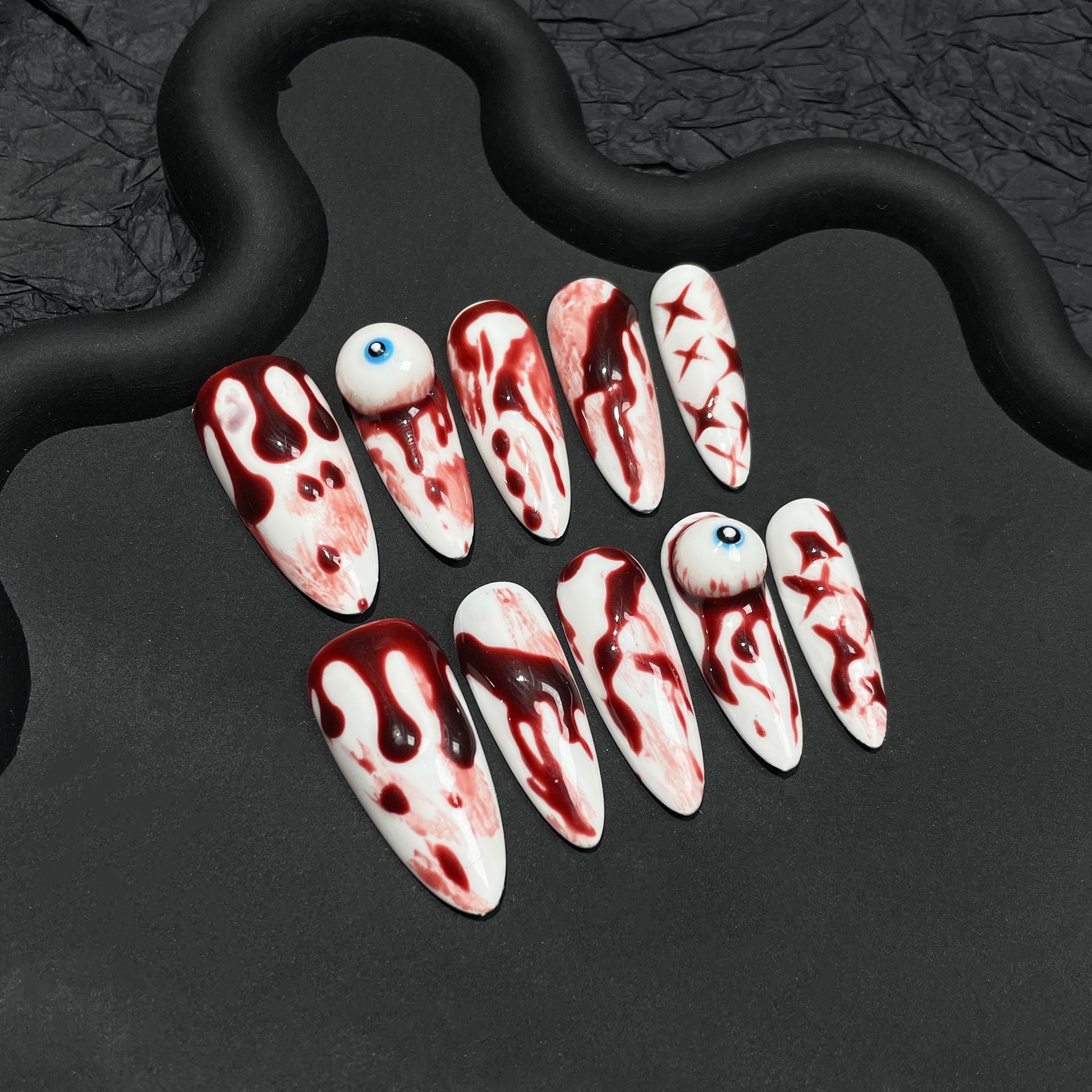 Unique Halloween nails with blood drip design and 3D eyeball feature