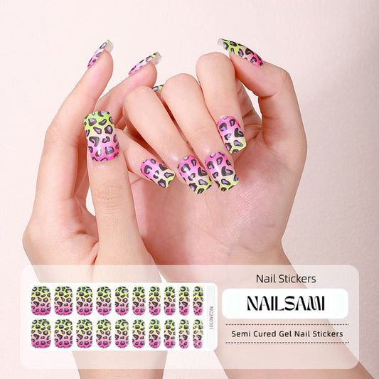 Hand with nails featuring a vibrant neon leopard print gel nail sticker design in green, pink, and yellow, with a NAILSAMI gel nail sticker sheet displayed below showing the same bold leopard print design.