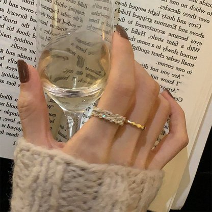 Gold-tone zircon-set and wavy metal adjustable rings styled on a hand