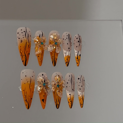 Amber ombre long stiletto press-on nails with raised clear flowers and black linework