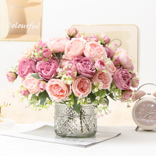 Mixed pink artificial peony and rose bouquets styled in a glass vase