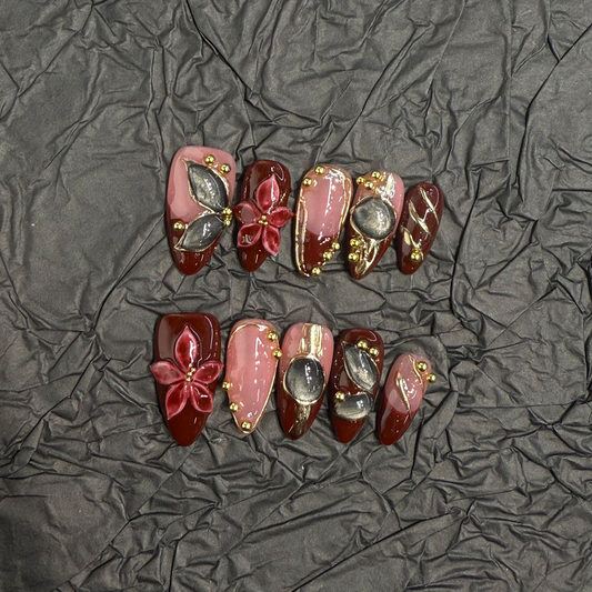 Almond press-on nail set with burgundy panels, raised flowers and smoky cat-eye details