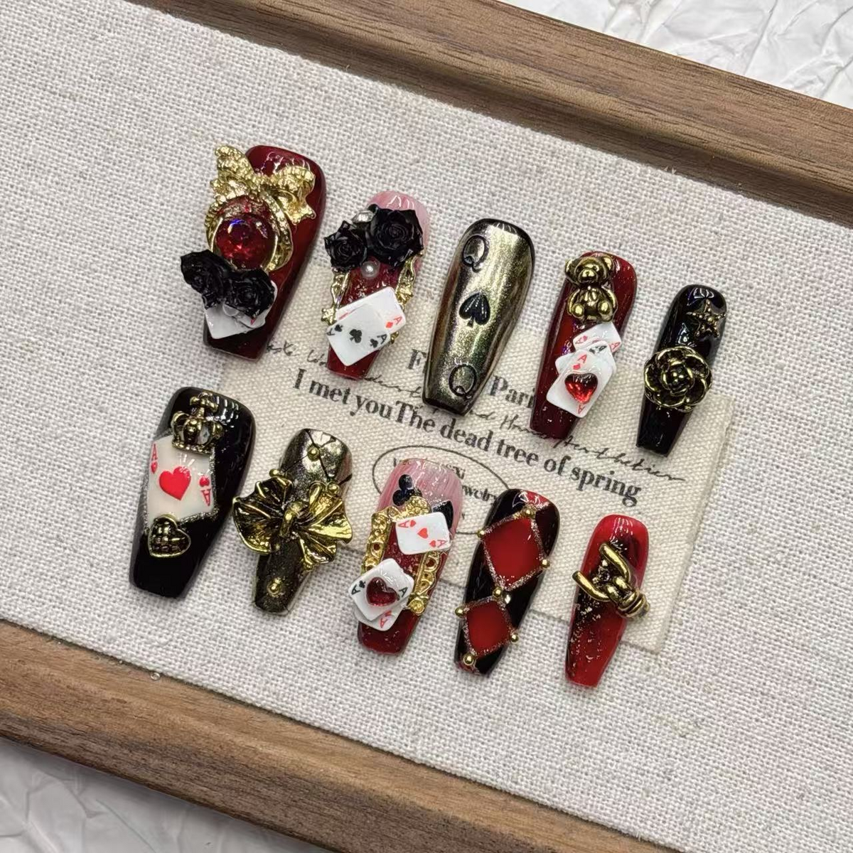 Medium coffin burgundy and black card-suit press-on nails with ornate gold accents