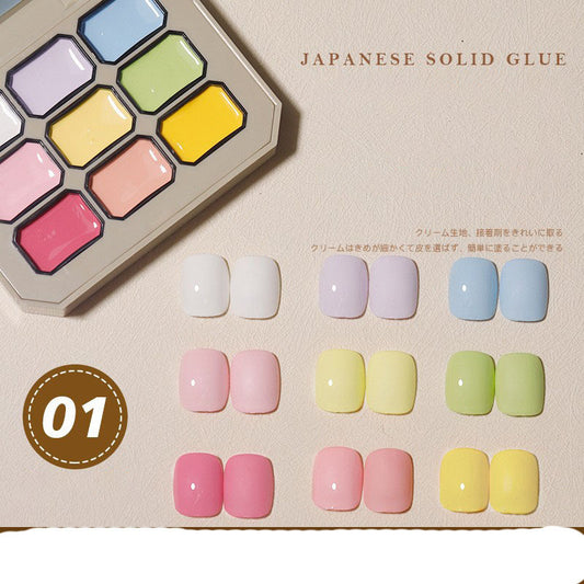 Palette of Japanese solid glue in nine colors displayed alongside a variety of colorful nail tips arranged in a grid. The label '01' and 'Japanese Solid Glue' text are visible.