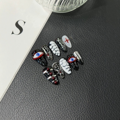 Black and red Halloween almond press-on nails with raised evil eyes and spiderwebs