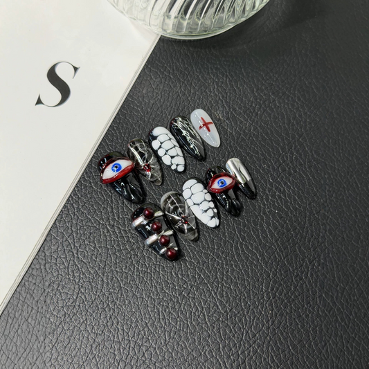 Black and red Halloween almond press-on nails with raised evil eyes and spiderwebs