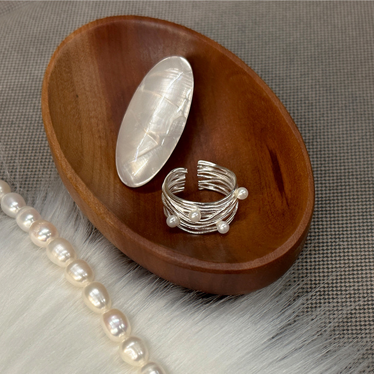 Irregular multi-layer pearl open ring displayed in a wooden styling dish