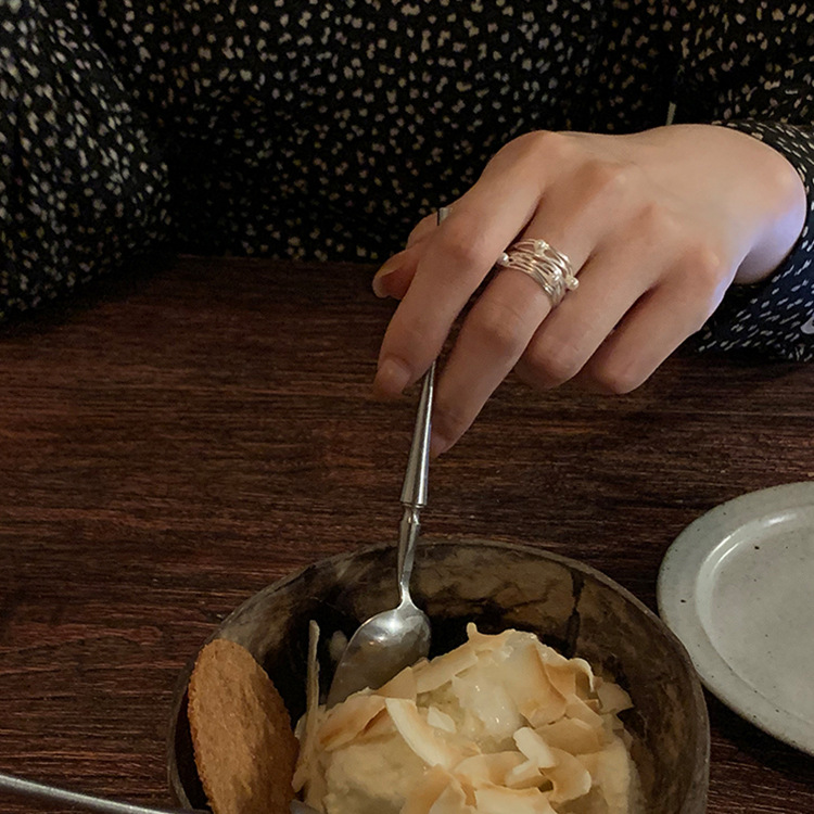Irregular pearl open ring worn in a warm dining setting