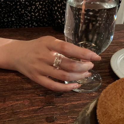 Close view of an irregular multi-layer pearl open ring worn on a hand