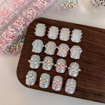 Pearl-style embellishments arranged in floral, bow and lattice nail art designs