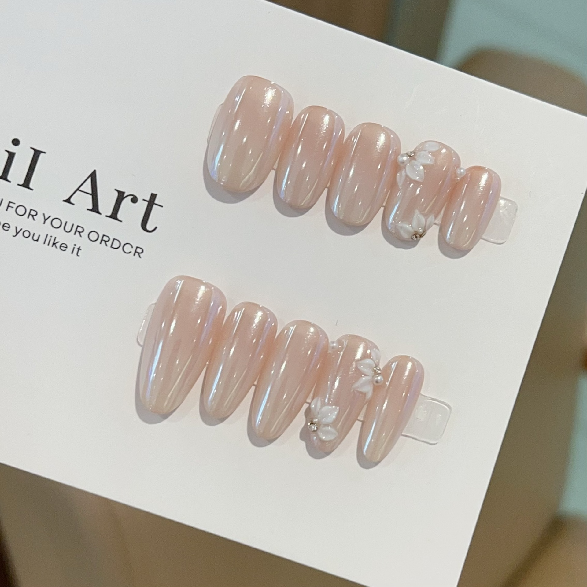 Moonlight nude-pink oval press-on nail set with raised white flowers and pearl accents