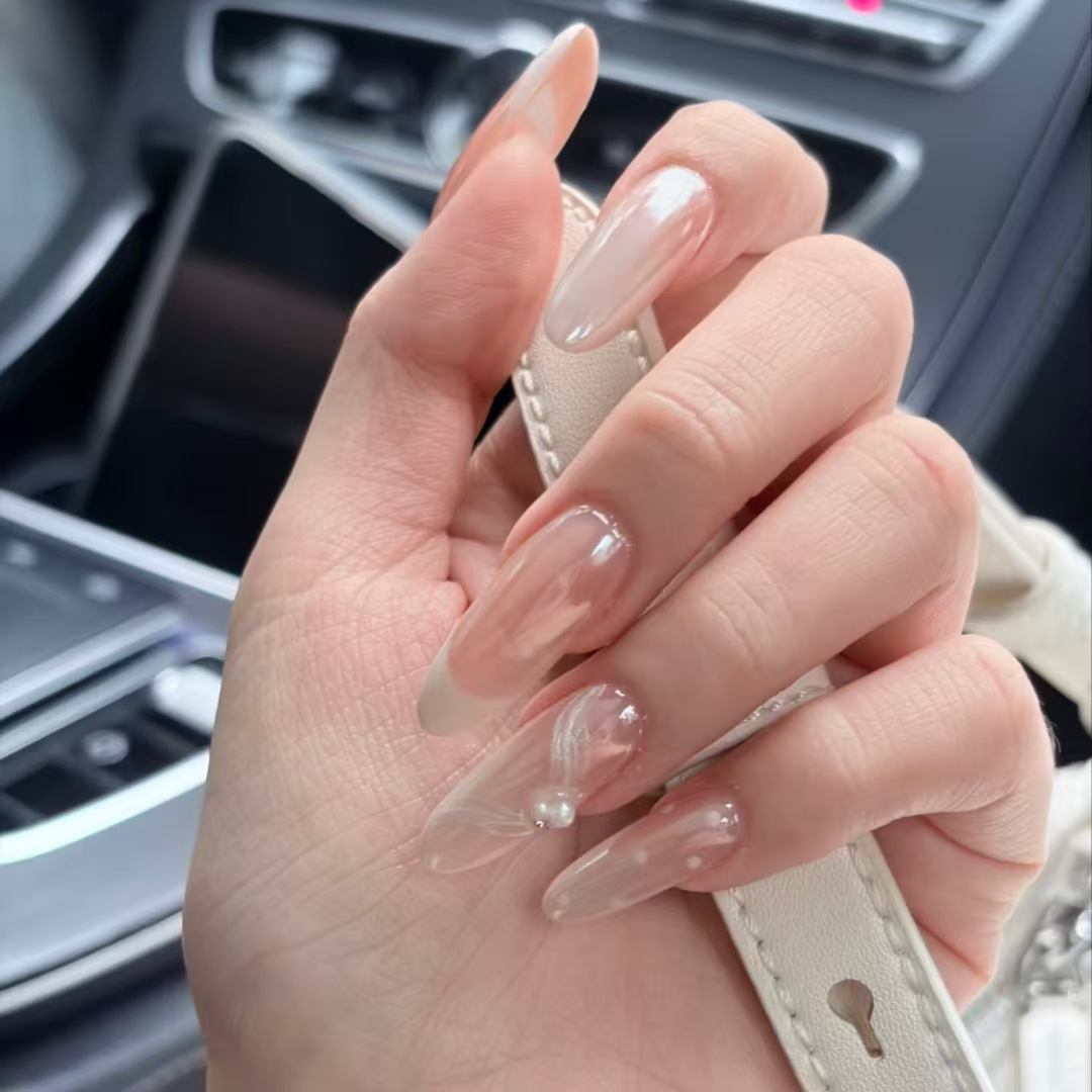 Glossy sheer pink almond press-on nails with aurora shine and pearl floral details