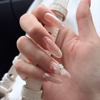 Close-up of long almond cat-eye press-on nails with a raised white flower accent