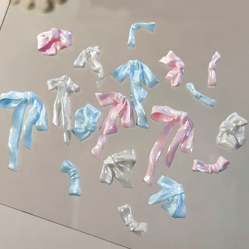Assorted pink, blue and white pearlescent resin bow nail decorations