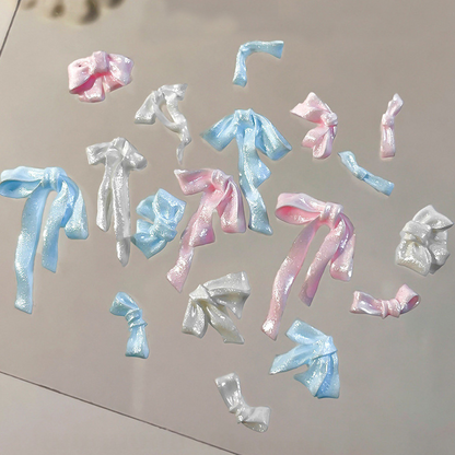 Assorted pink, blue and white pearlescent resin bow nail decorations
