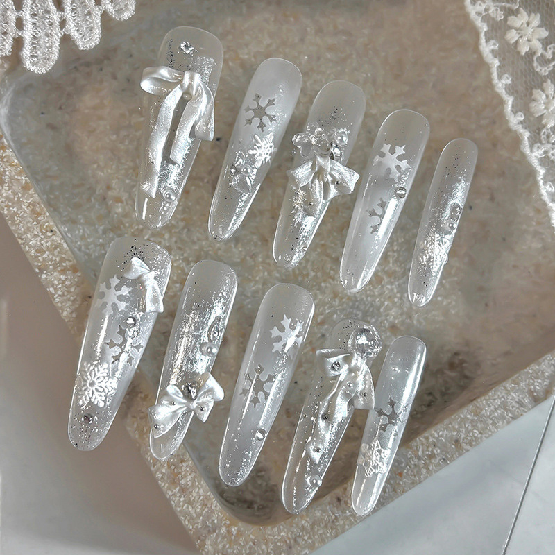 Silver and white manicure featuring pearl white resin bow decorations