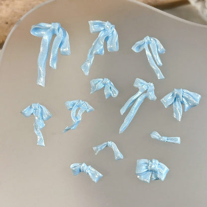 Assorted pearl blue resin ribbon bows in multiple shapes