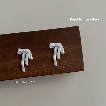 Pearl white resin bow style 1 measuring approximately 10 by 15 millimetres