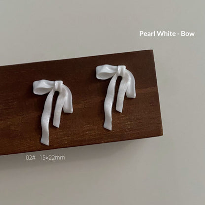 Pearl white resin bow style 2 measuring approximately 15 by 22 millimetres