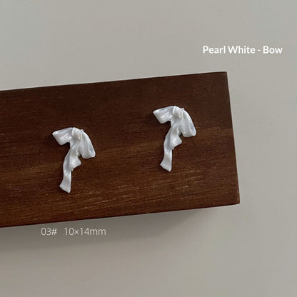 Pearl white resin bow style 3 measuring approximately 10 by 14 millimetres