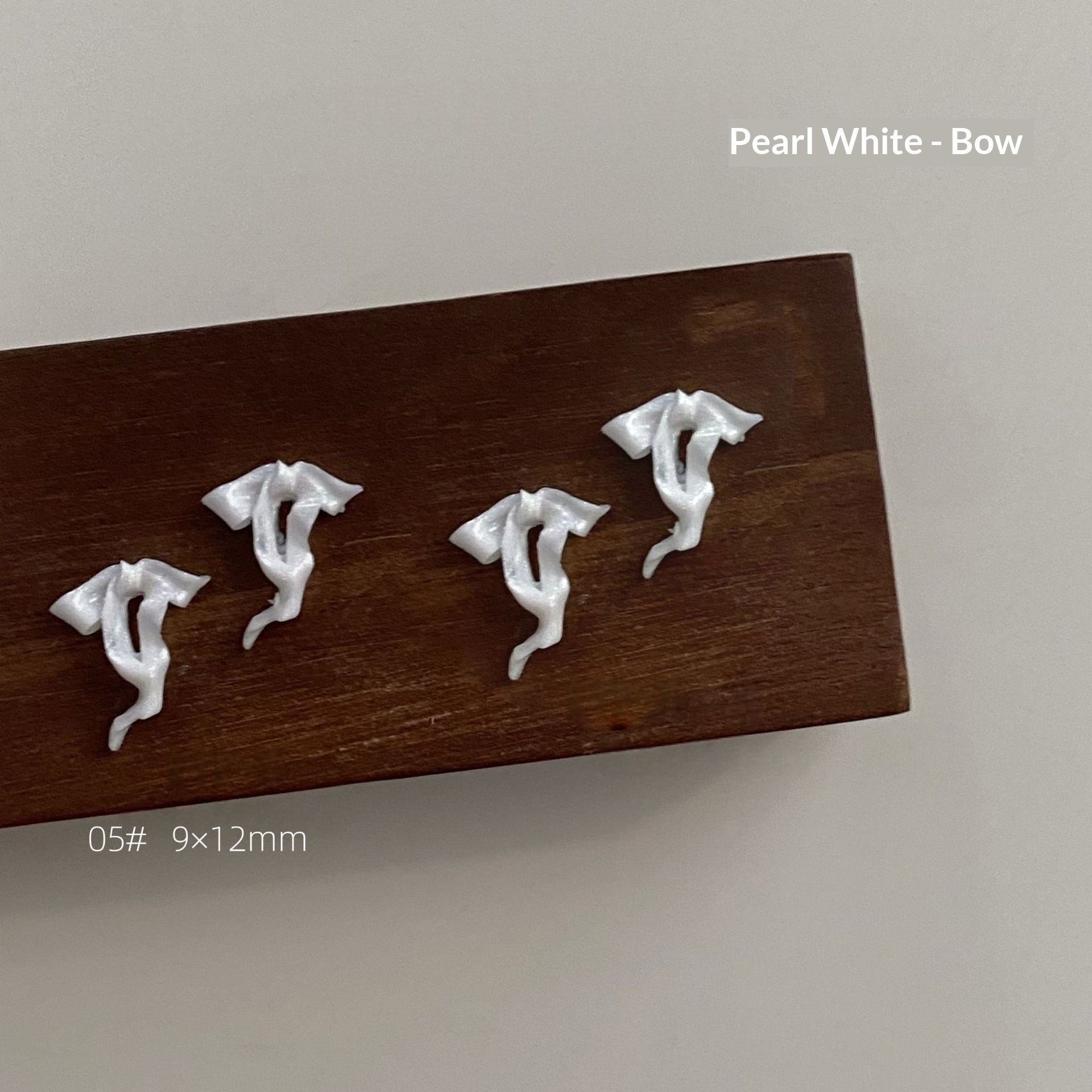 Pearl white resin bow style 5 measuring approximately 9 by 12 millimetres