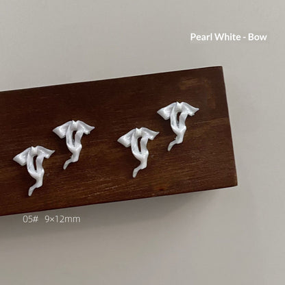 Pearl white resin bow style 5 measuring approximately 9 by 12 millimetres