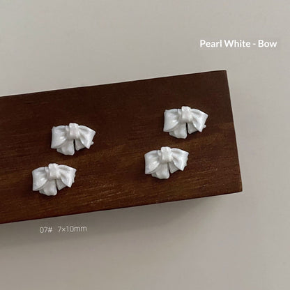 Pearl white resin bow style 7 measuring approximately 7 by 10 millimetres