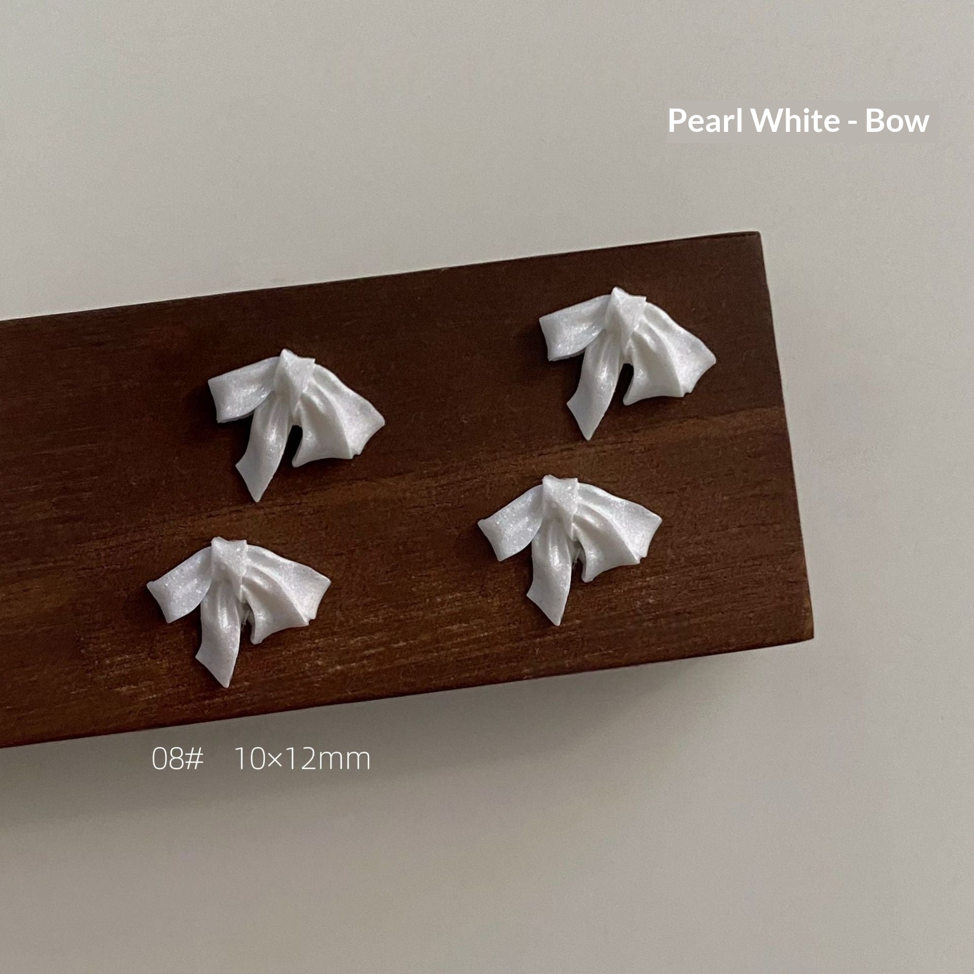 Pearl white resin bow style 8 measuring approximately 10 by 12 millimetres