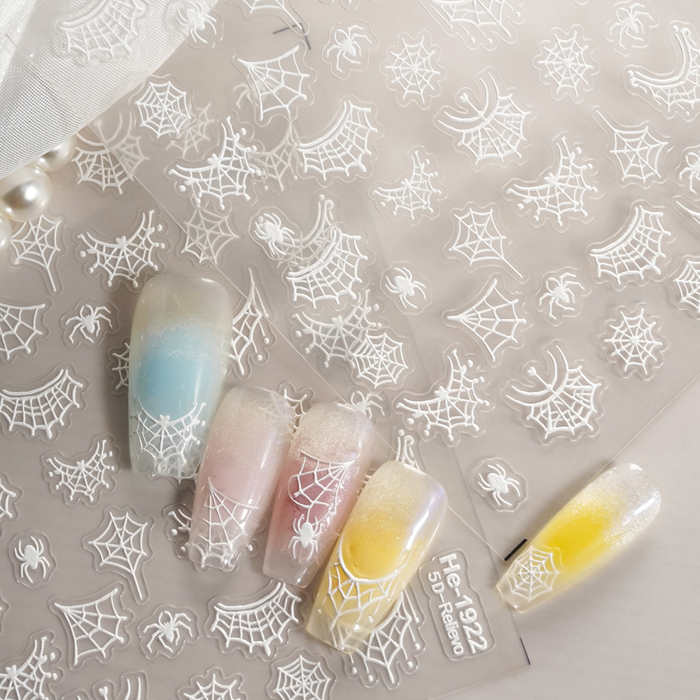 White embossed spider and spider web nail sticker sheet with pastel nail examples