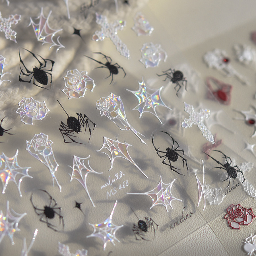 Close-up of TOMONI MS468 black spider and iridescent web and rose nail stickers