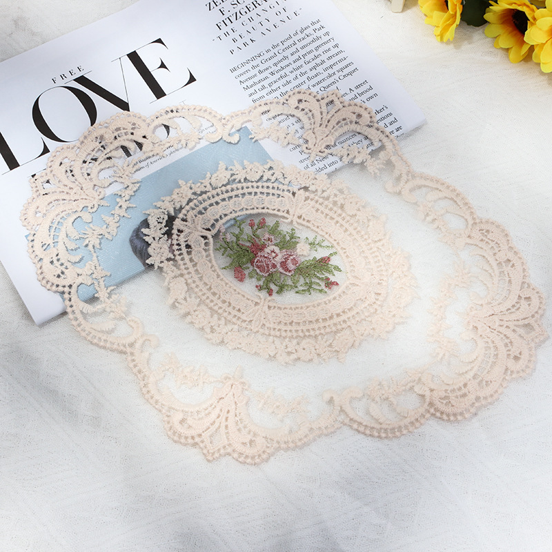 Beige oval floral embroidered lace mat styled with a magazine and flowers