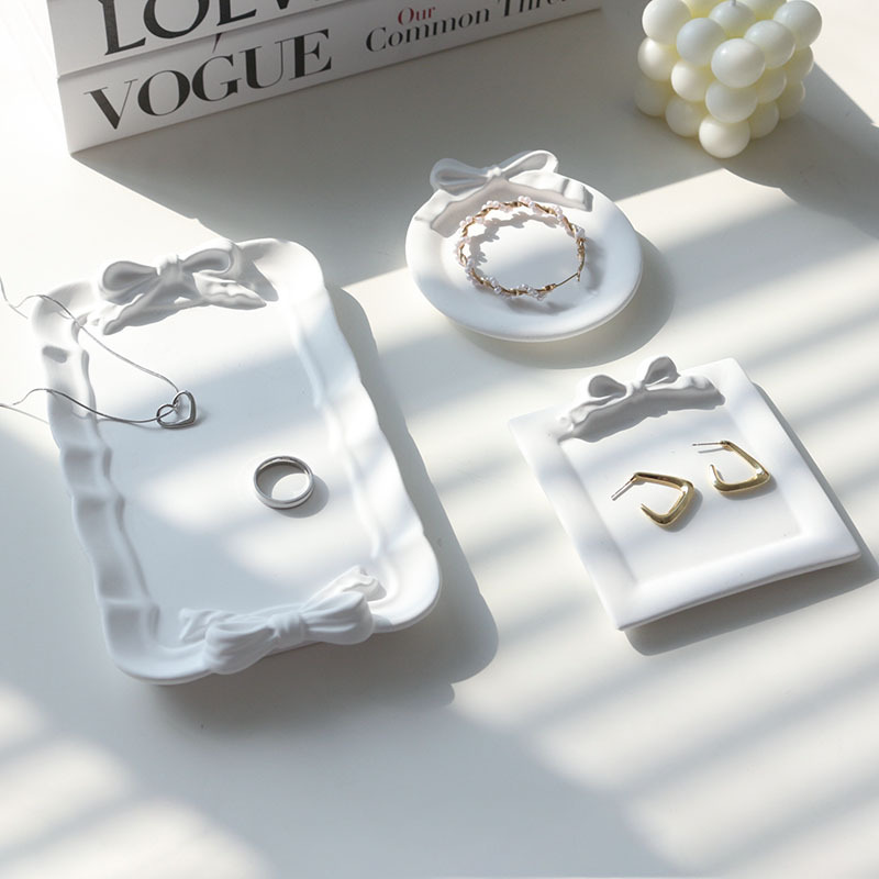 Rectangle, square and round white bow plaster trays styled with jewellery