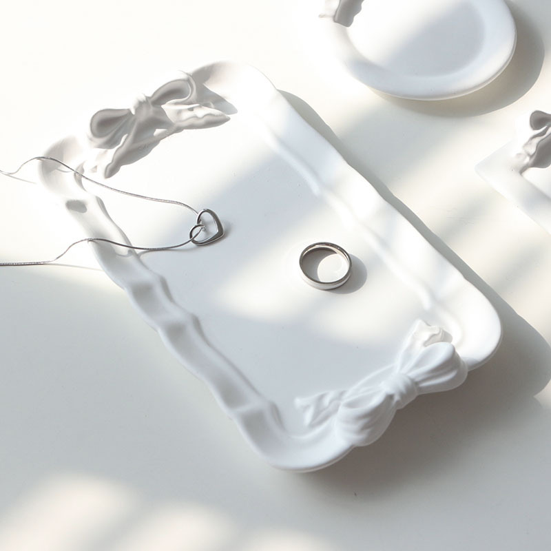 Rectangle white bow plaster display tray styled with silver jewellery